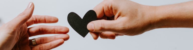 person handing heart to another hand, relationship between humans and psychedelics