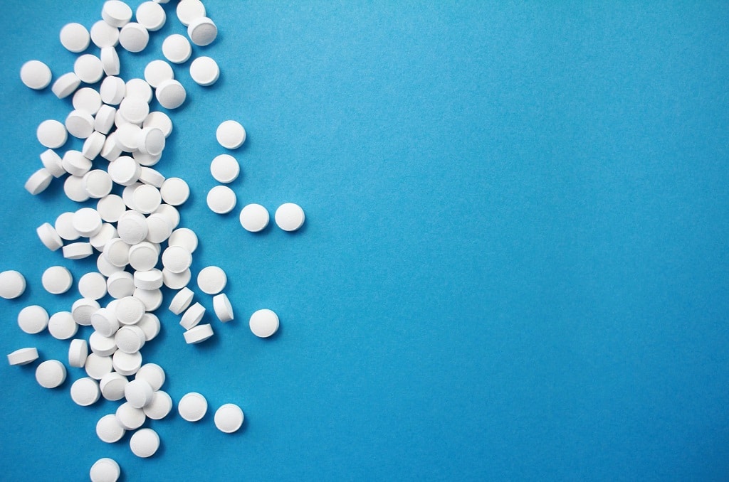 white pills on blue background, traditional medicine versus transcendental healing