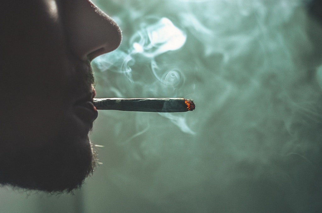 man smoking joint, cannabis pharmacology and therapeutic benefits
