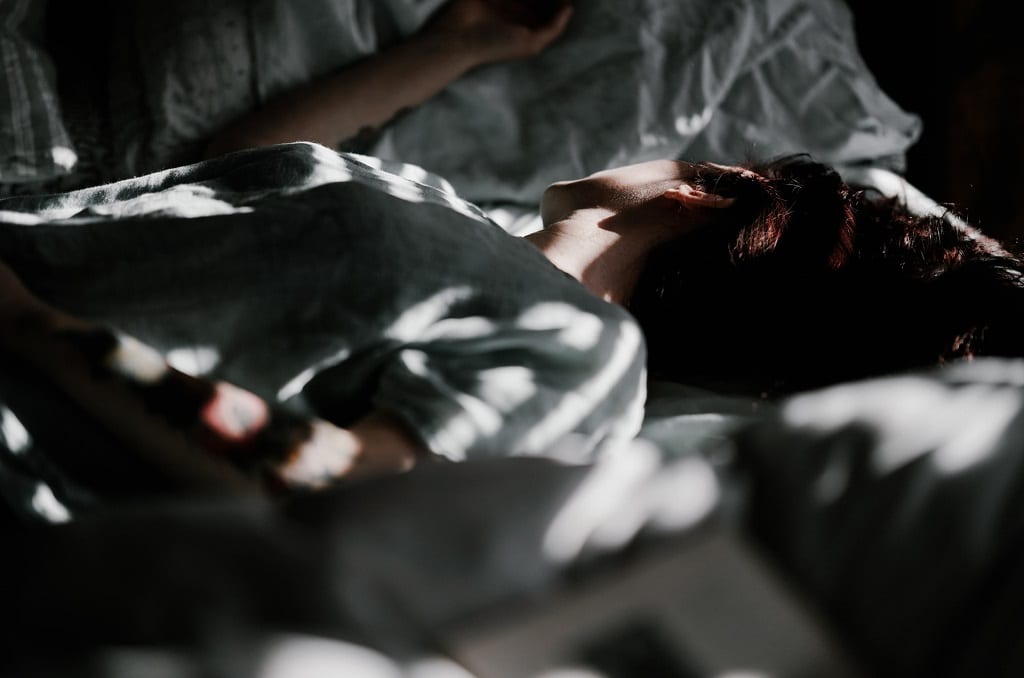 woman laying in dark room, psilocybin therapeutic benefits