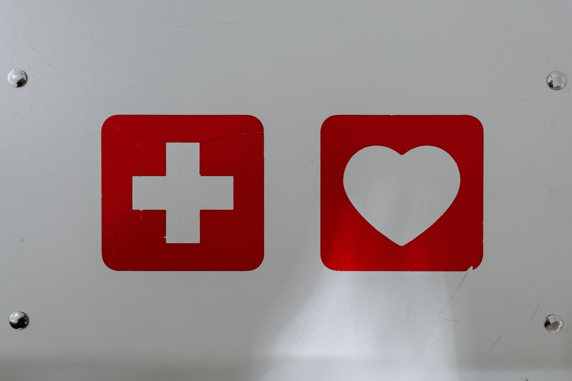 red cross and red heart on white wall