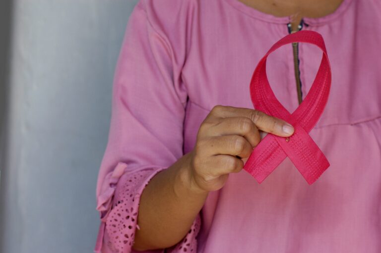woman holding pink cancer ribbon